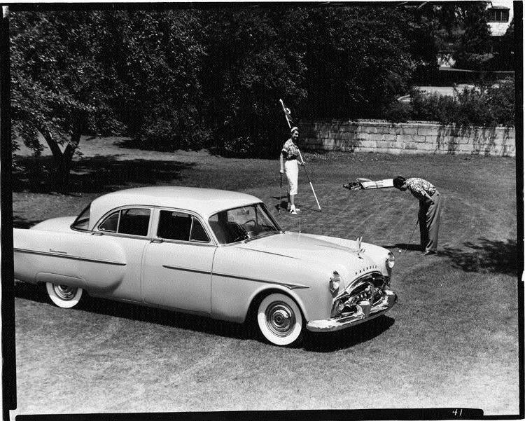 1951 Packard sedan, seven-eights right side view, couple on green playing golf