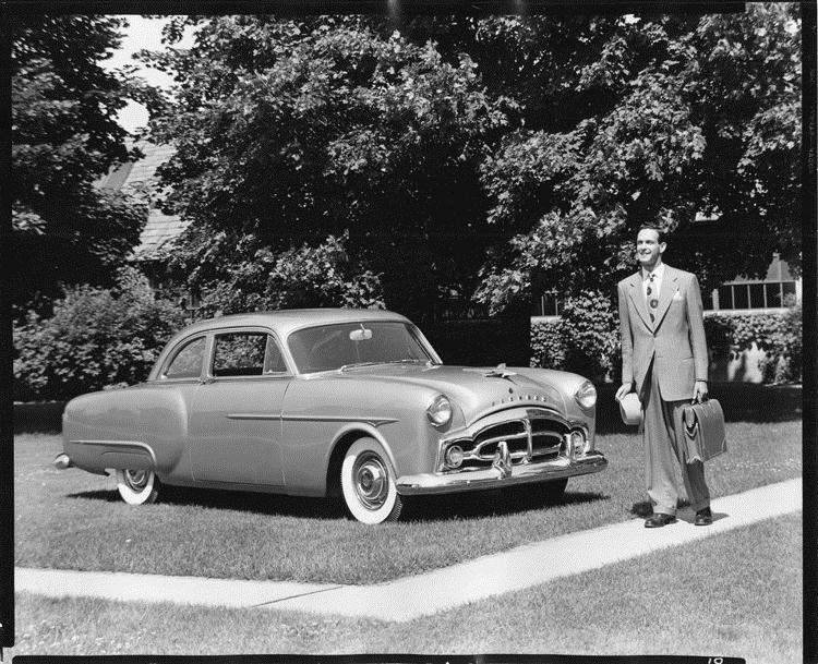 1951 Packard 200 sedan, parked on grass, man standing near front of car