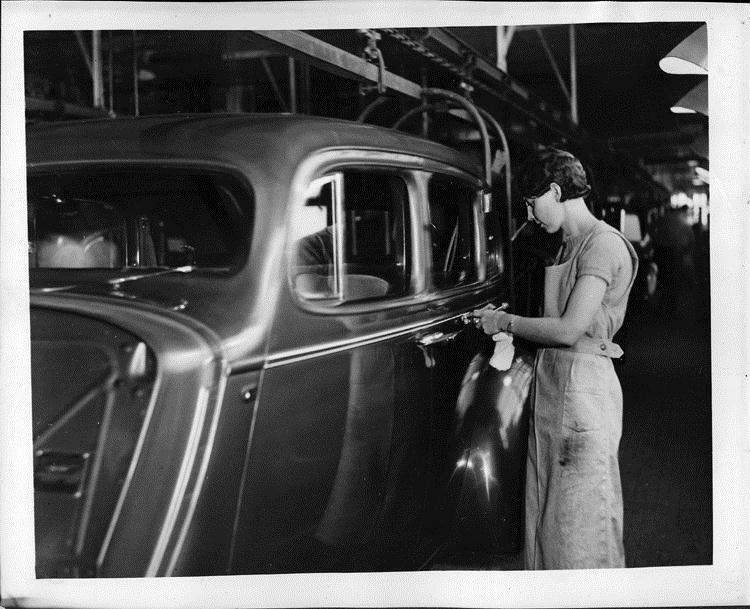 Female automobile worker applying body striping on Packard assembly line, 1936