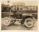1904 Packard Model L with driver & passenger in front of Packard Motor Car Co.