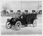 1908 Packard 30 Model UA touring car with houses in background on winter street