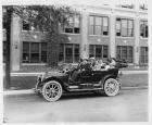 1910 Packard 30 Model UC, parked on street in front of Packard plant, with family of six and chauffe