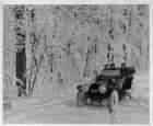 1912 Packard phaeton, on winter road, with male driver and two passengers