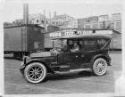 1917 Packard touring car in rail yard, several buildings in background