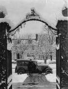 1922 Packard touring car, parked on street, seen through large iron gate in winter