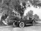 1920-1923 Packard phaeton on residential street next to group of people under a tree