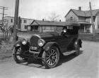 1923 Packard touring car coming around corner on residential street