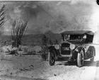 1923 Packard touring car, front view, top raised, on desert road with male driver