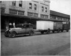 1924 Packard sedan, three-quarter left front view, hauling three cargo wagons