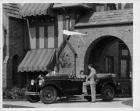1929 Packard phaeton at entrance to large brick home, female at wheel