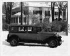 1930 Packard sedan, right side view, parked on snowy street, in front of house