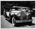 1930 Packard roadster, three-quarter front view, top raised, people standing in background