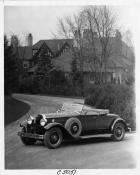 1930 Packard roadster, three-quarter right front view, top folded, parked on road, house in backgrou