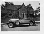 1930 Packard phaeton, left side view, top folded, parked on street in front of house