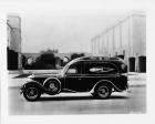 1930 Packard special funeral coach, left side view, male driver, parked on street