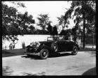 1932 Packard coupe roadster, top folded, parked by gate of Packard Proving Grounds