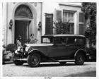 1932 Packard sedan parked on drive in front of house, women at doorway