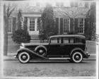 1933 Packard sedan, left side view, parked on street in front of house