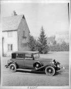 1933 Packard club sedan, parked on drive next to stone house
