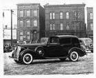 1936 Packard cabriolet, seven-eights left side view, apartment buildings in background
