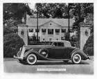 1936 Packard coupe roadster, parked in front of gateway, house in background