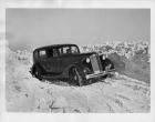1936 Packard sedan, coming around snowy corner, male driver and passenger