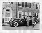 1936 Packard sedan, parked on drive, two men standing at driver's door