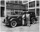 1936 Packard sedan in front of Packard plant, Donderos standing by driver's door
