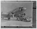 1937 Packard coupe roadster, parked in front of large twin engine airplane