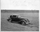 1937 Packard club sedan parked in dirt field at Packard Proving Grounds