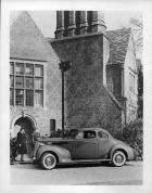 1938 Packard club coupe, left side view, parked in front of house, couple standing at door