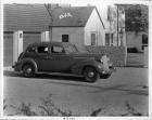 1938 Packard touring sedan parked in driveway of house
