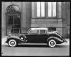 1938 Packard touring cabriolet, left side view, parked on street in front of building