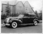 1938 Packard all weather cabriolet parked on street in front of house