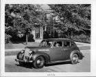 1938 Packard touring sedan parked in front of house, two couples in car