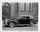 1938 Packard touring cabriolet, left side view, parked on street in front of building