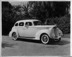 1939 Packard touring sedan, two female passengers, man standing by driver's door