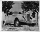 1940 Packard touring sedan parked on grass with two women