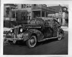 1940 Packard touring sedan, driver's side, parked on street, covered in mud