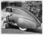 1942 Packard club sedan, female gesturing at car's features