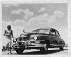 1948 Packard sedan, woman standing at front right side of car