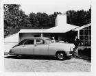 1948 Packard touring sedan, parked in driveway in front of home, couple standing at front of car