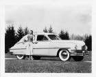 1949 Packard sedan, parked on grass, female standing at front passenger door