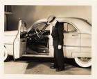 1950 Packard custom sedan, left side view, Mike Kollins standing at open driver's door