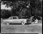 1951 Packard sedan, couple having a picnic under tree near front of car