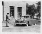 1951 Packard 200 business coupe, man holding blue prints standing near front of car