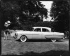 1951 Packard 300 sedan parked on grass and female with back to camera