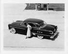 1951 Packard Patrician 400 parked near gas pump with stylish woman