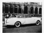 1953 Packard 2-door sedan, parked on street, two men looking at rear windshield