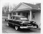1953 Packard formal sedan, parked in driveway in front of house